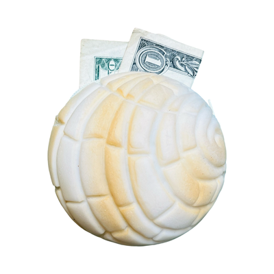 round rubber cream concha coin purse with a dollar bill
