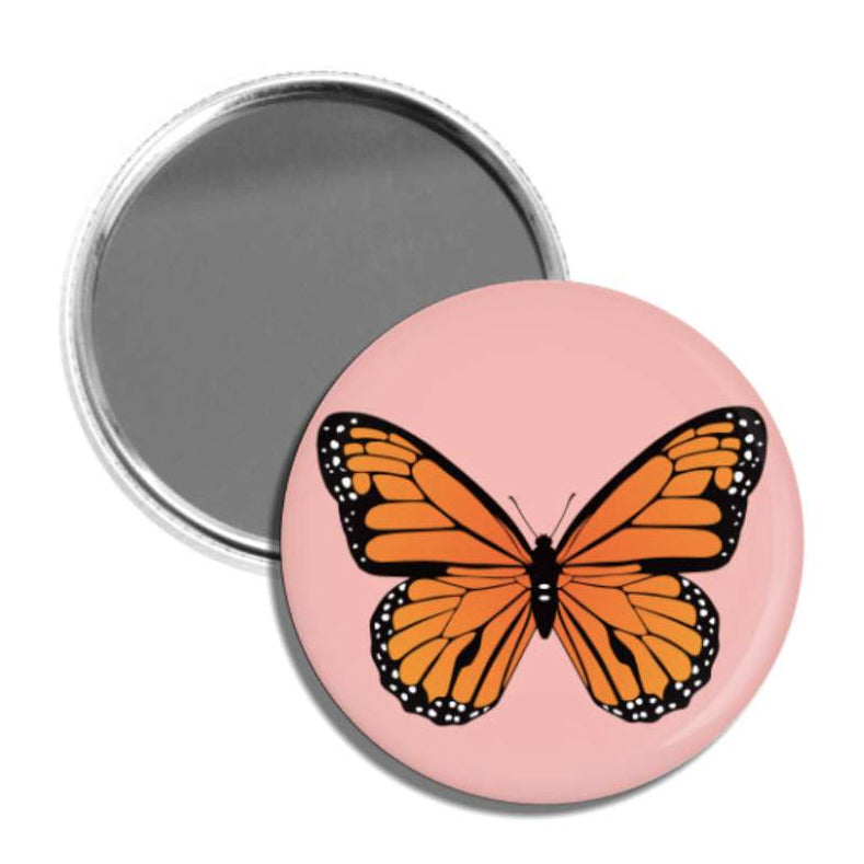 set of two round pocket mirrors. one is pink and has the image of a monarch butterfly and the other is the mirror itself.