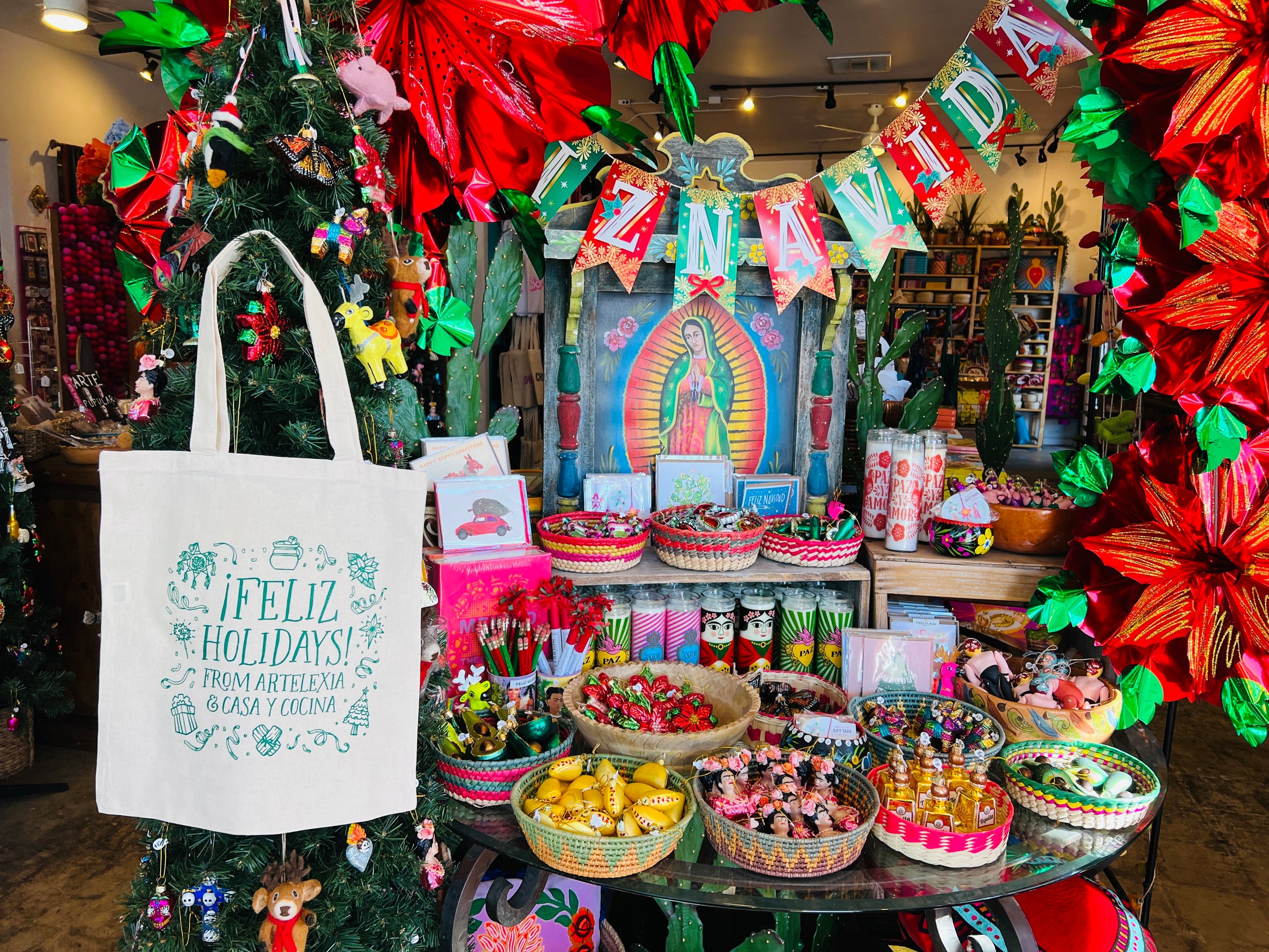Artelexia front entry display featuring a canvas colored tote bag that reads "Feliz Holidays From Artelexia & Casa Y Cocina"
