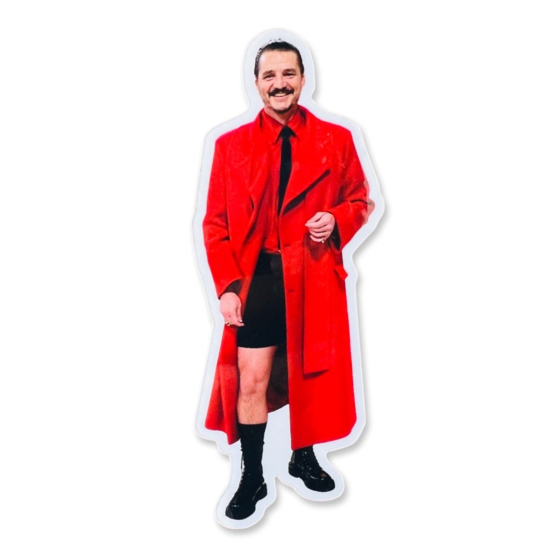 Actor Pedro Pascal in a red trench coat, red shirt and black shorts.