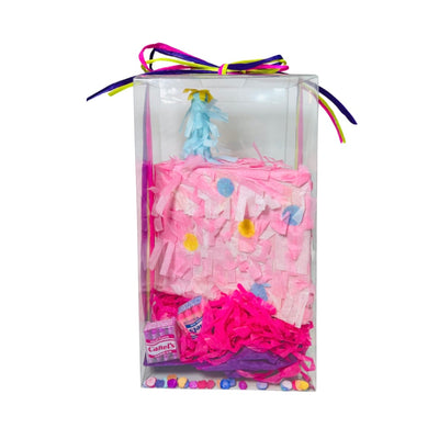 pink piñata with a blue candle and colorful confetti in a clear box tied with colorful ribbon.