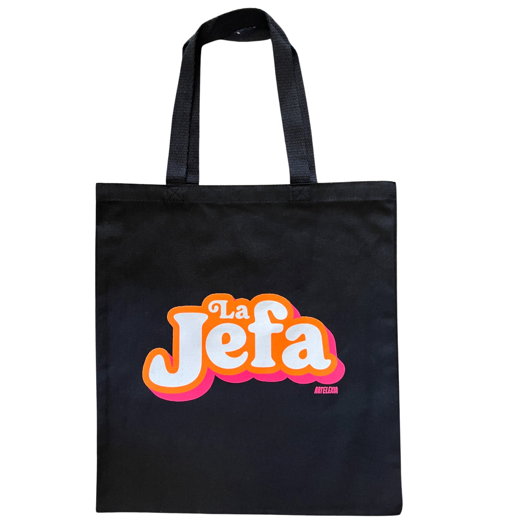 Black canvas tote bag featuring the phrase "La Jefa" in white lettering with an orange and pink outline