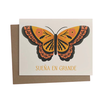 beige card with an image of a black and orange butterly and the phrase Sueña En Grande in orange lettering. Translation: Dream Big