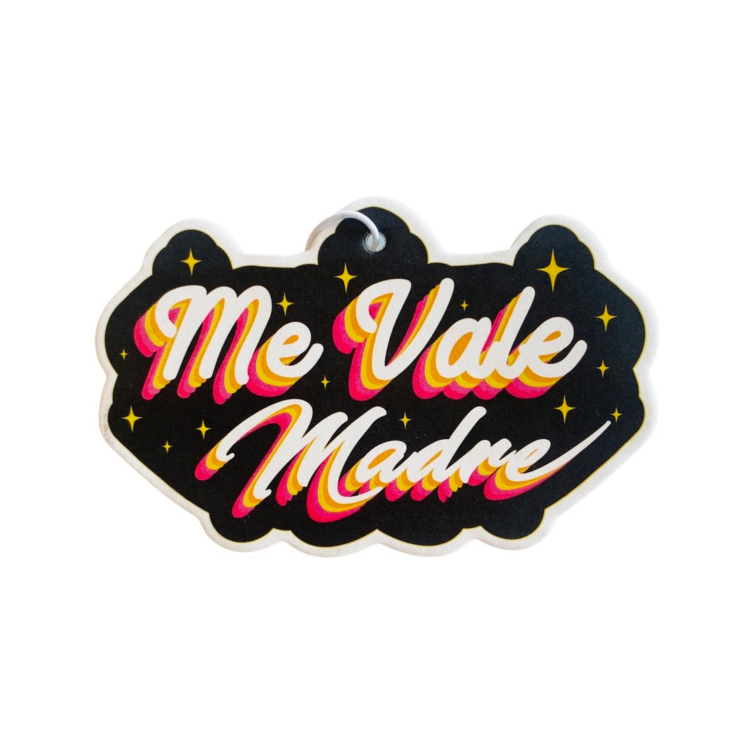 Black air freshener with colorful text that read: Me Vale Madre.