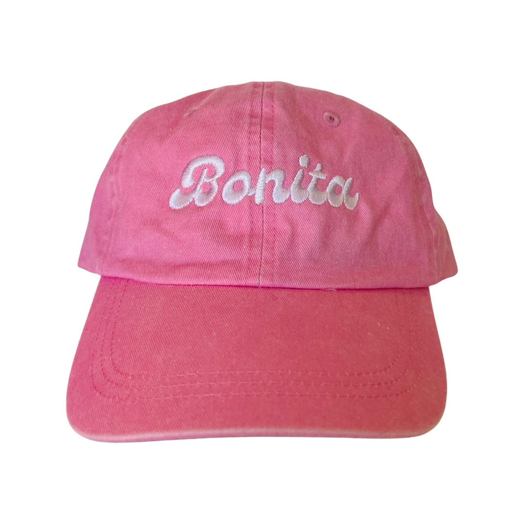 Pink dad cap with the word Bonita is white lettering. 