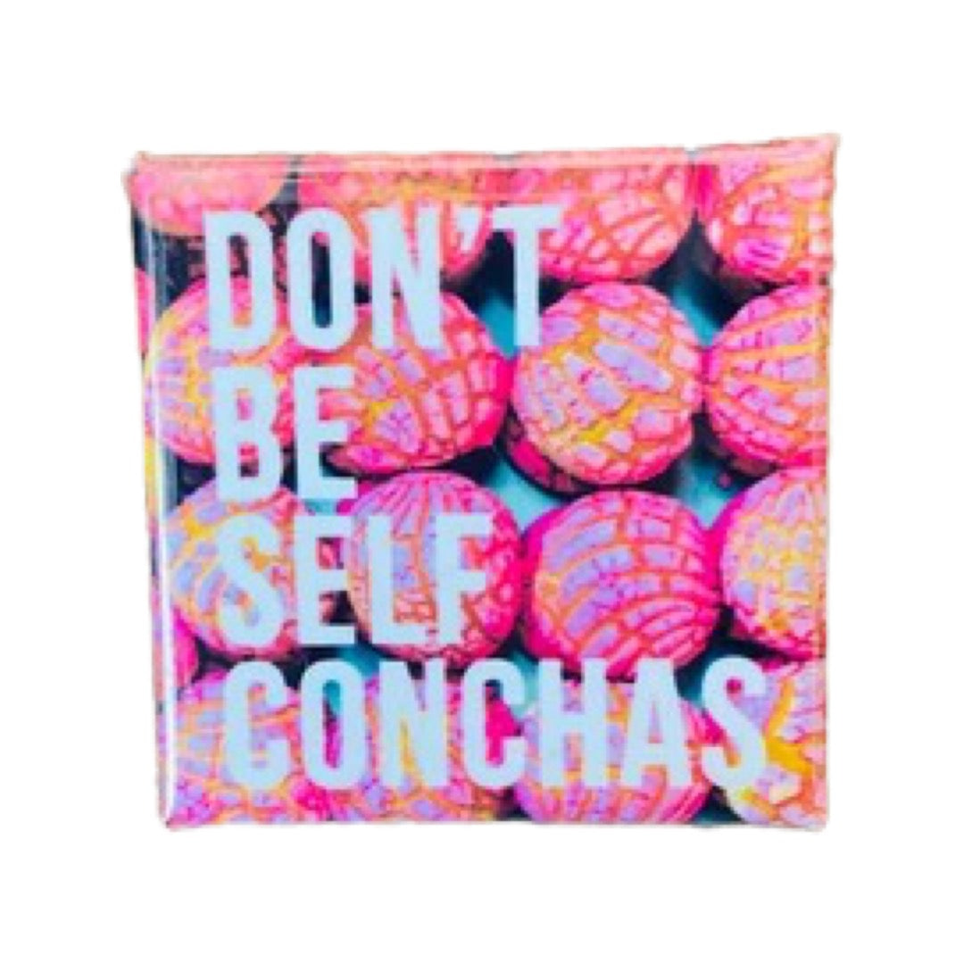 Square pin with an image of pink conchas and the phrase Don't Be Self Conchas in white lettering