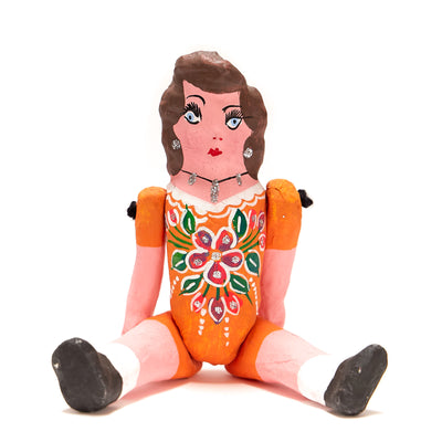 Paper Mache Muñeca (Doll) with movable arms and legs. Doll is wearing a light orange dress.