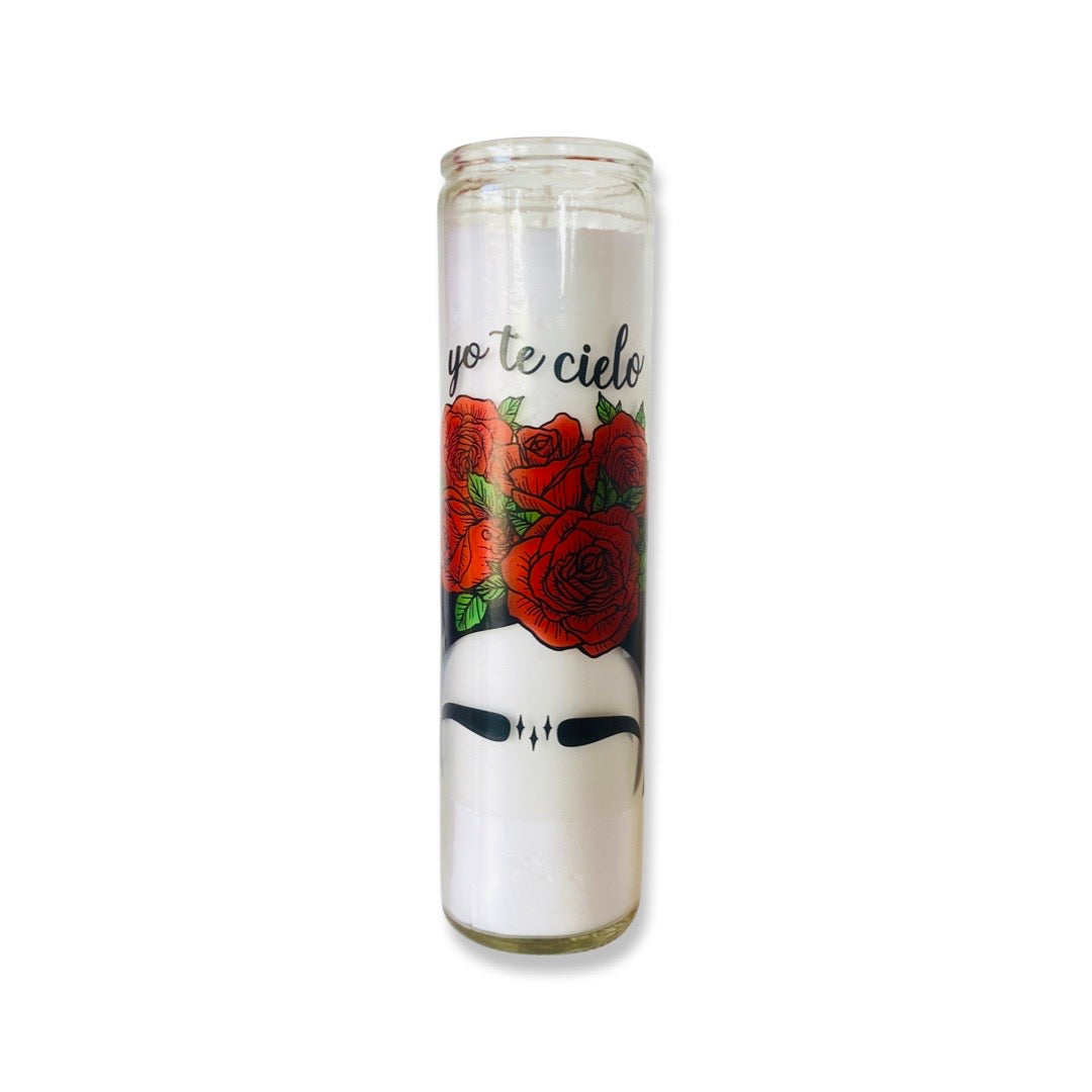 Tall candle features Frida's iconic eyebrows surrounded by roses and the quotes "Yo Te Cielo." 