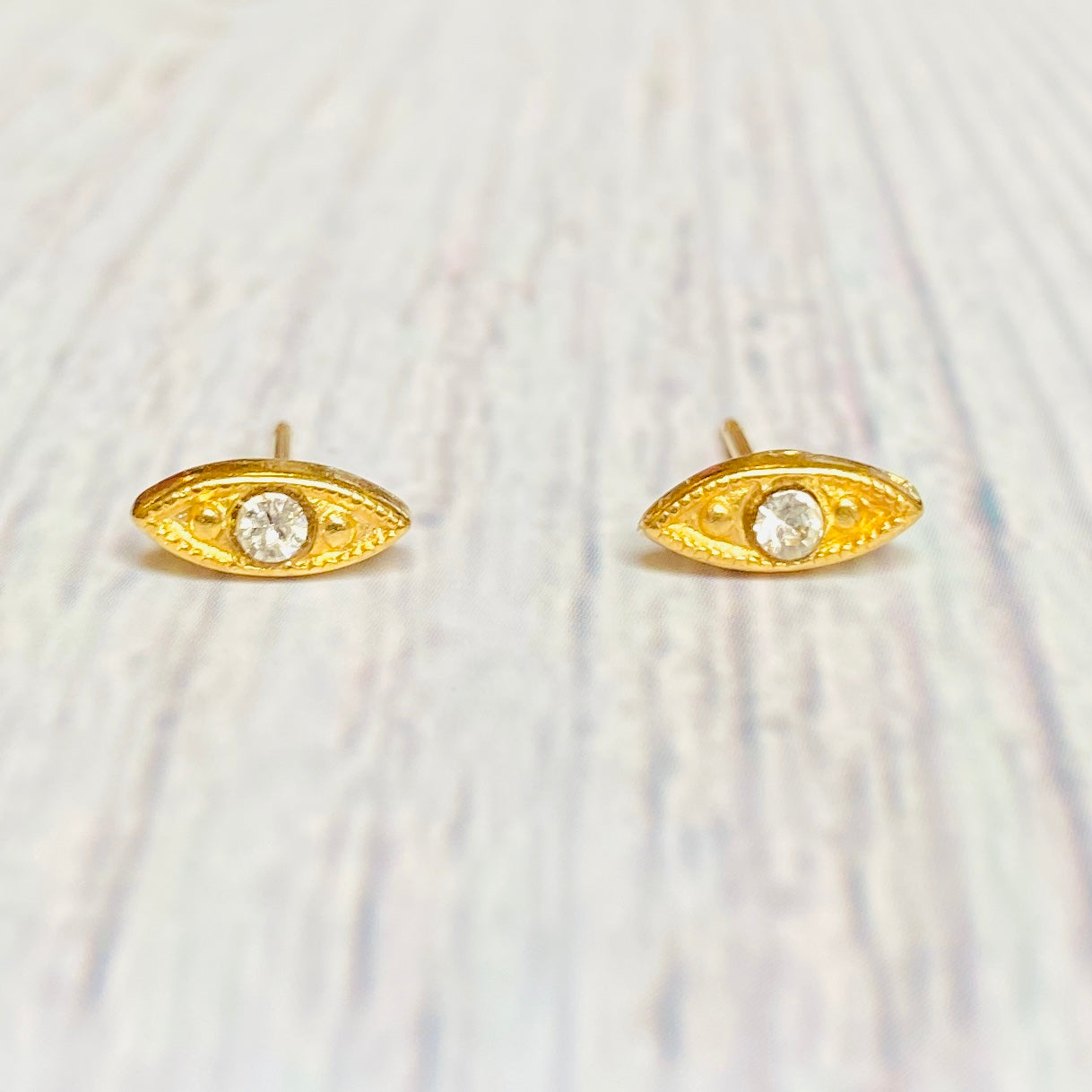 Gold plated brass eyes stud earrings with crystals.