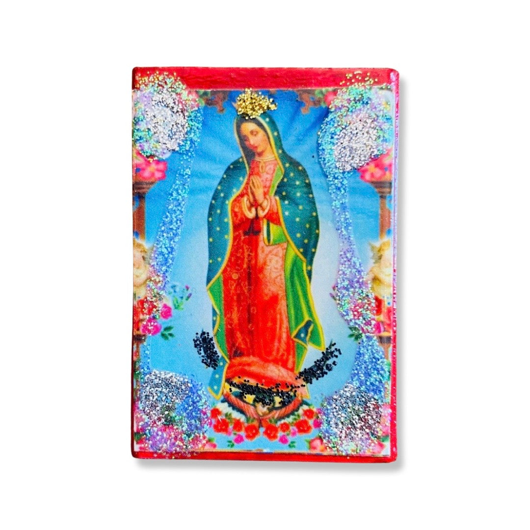 Blue matchboxes with the image of the Virgen de Guadalupe and silver glitter on the sides.
