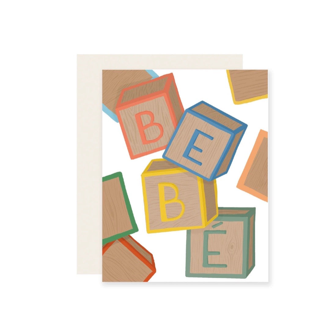 White card with wooden blocks that spell out the word BEBE
