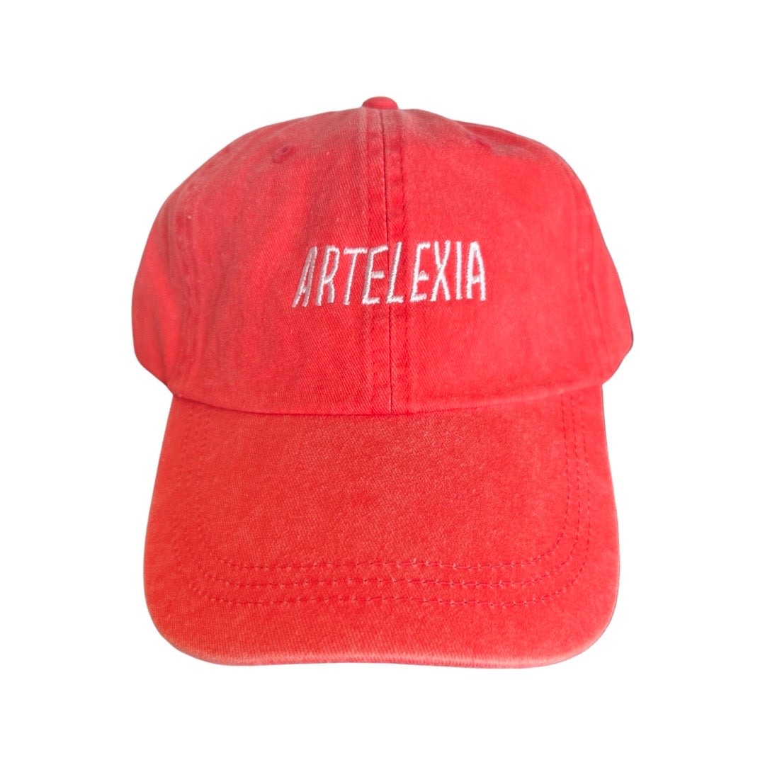 coral hat with the word Artelexia in white lettering
