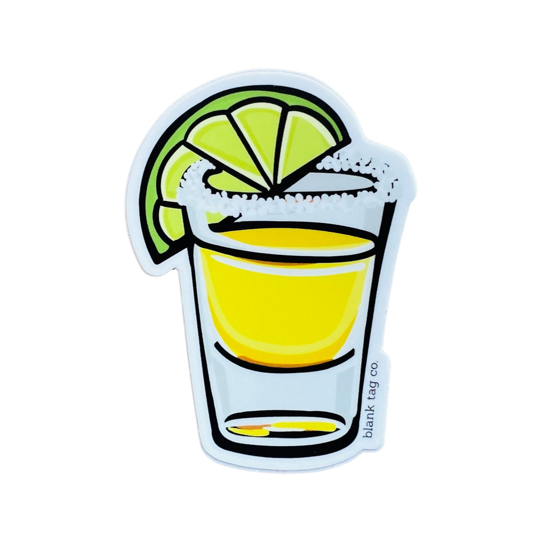 Image of a single shot of tequila with salt and a slice of lime on the rim.