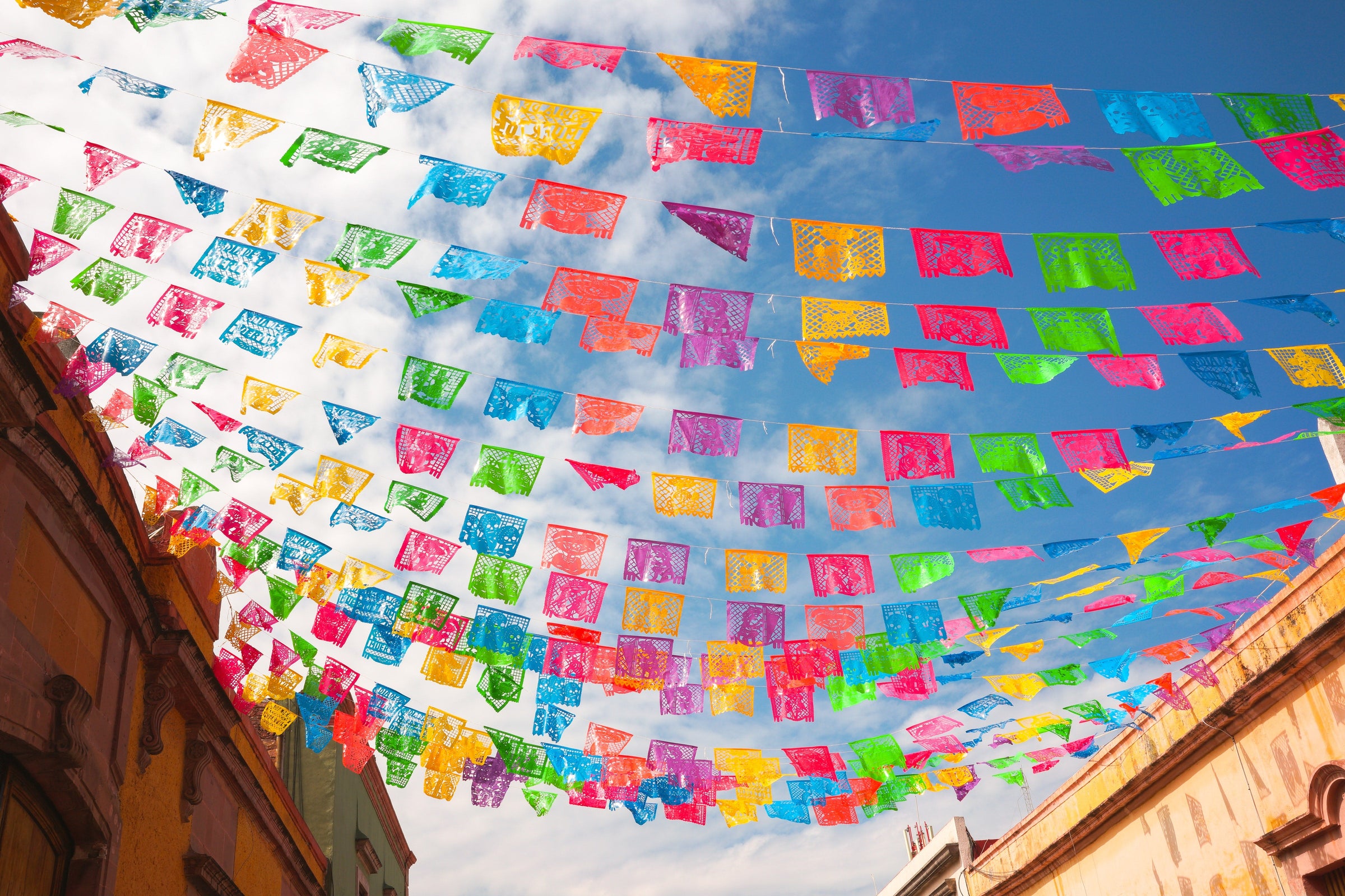 colorful papel picado banners hanging between buildings