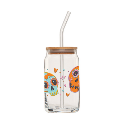 Second side of clear glass can tumbler with a glass straw featuring two colorful sugar skulls, hearts and flowers.