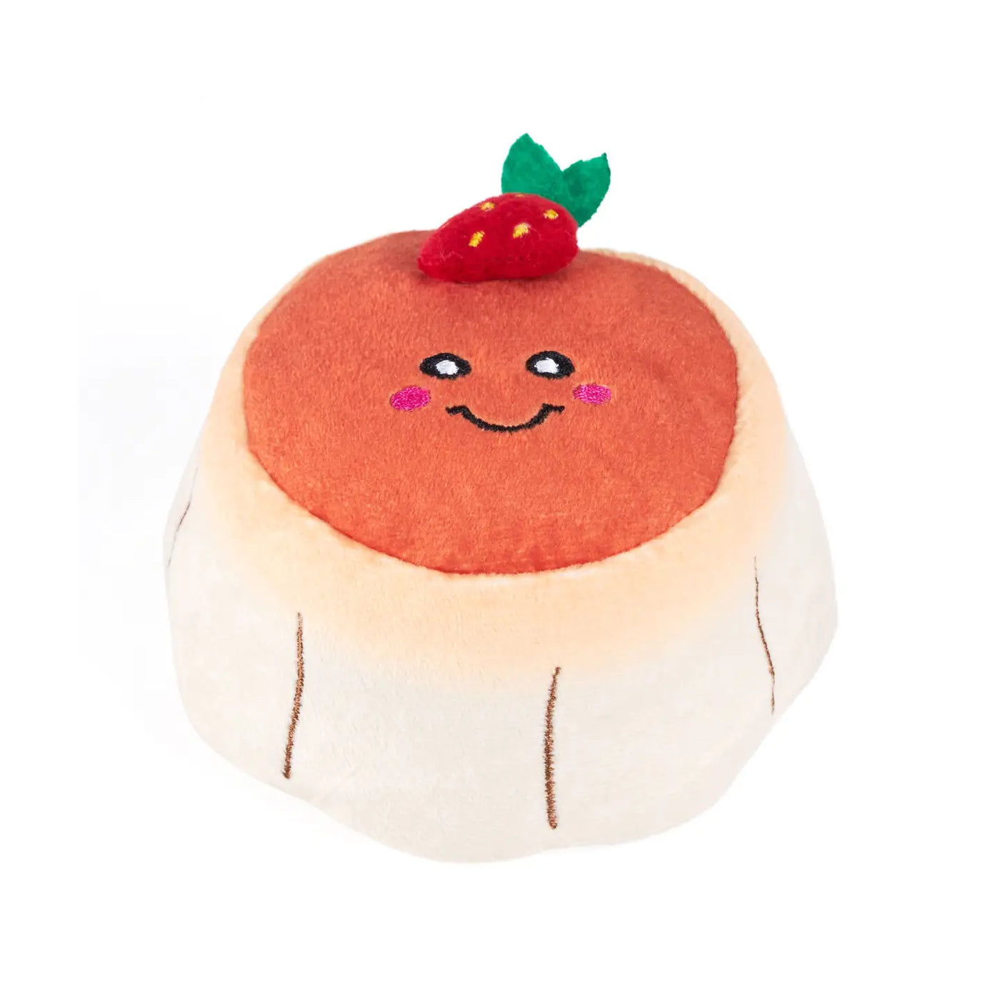 cream and orange flan shaped dog toy with a strawberry and smiley face on top.