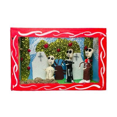 red nicho box that features a scene with skeletons in a cemetery