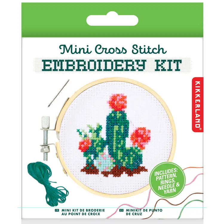 Mini cross stitch embroidery kit featuring a cactus design with red flowers, shown inside a wooden hoop with included yarn and needle.
