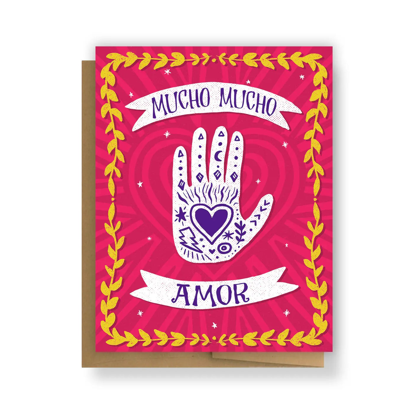 A colorful greeting card with a pink background, featuring a white mystical hand illustration with a heart at its center, surrounded by the phrase "Mucho Mucho Amor" and framed with yellow floral accents. Includes a kraft envelope.