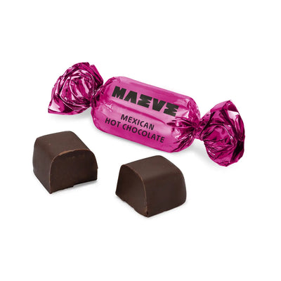 one bonbon individually wrapped in shiny magenta foil, with an unwrapped piece showing smooth dark chocolate with a creamy spiced filling.