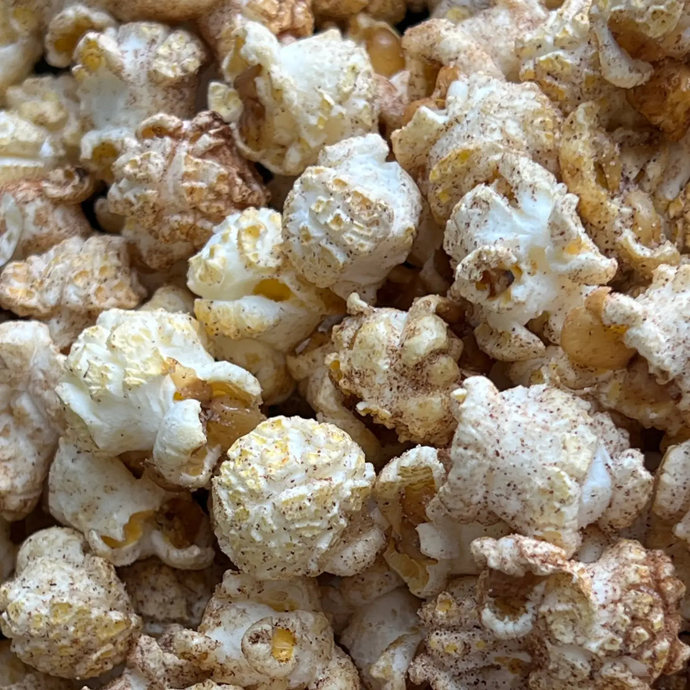 close up of popped popcorn with hot chocolate powder.