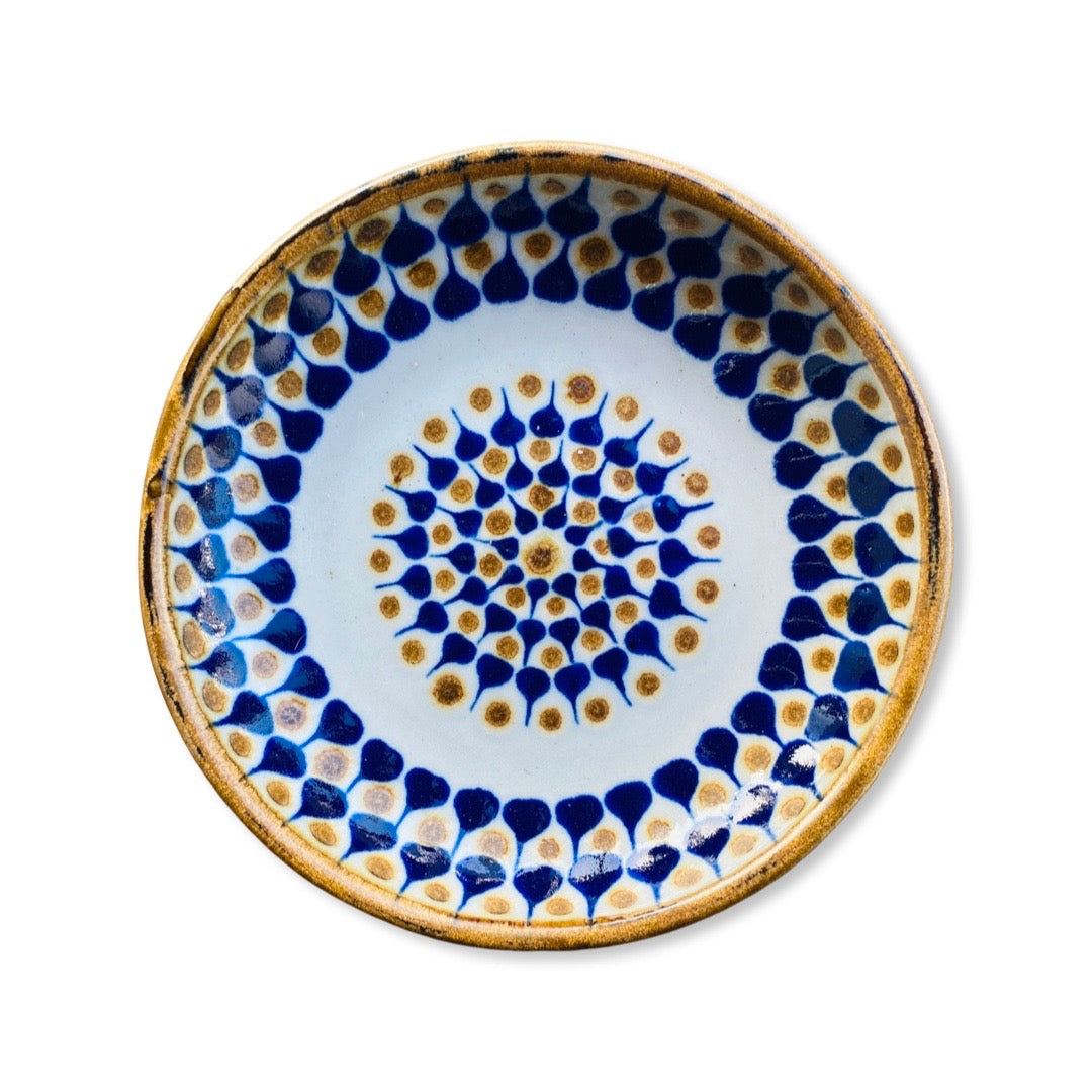 Cream ceramic plate with a blue and brown design