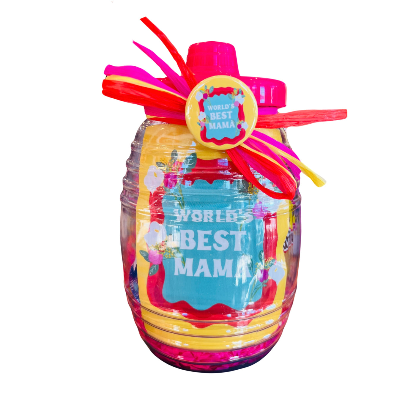 clear jar with a pink lid filled with Mexican candy and features a Yellow sticker and pin-button with the phrase World's Best Mama in white lettering, tied with colorful raffia ribbon.