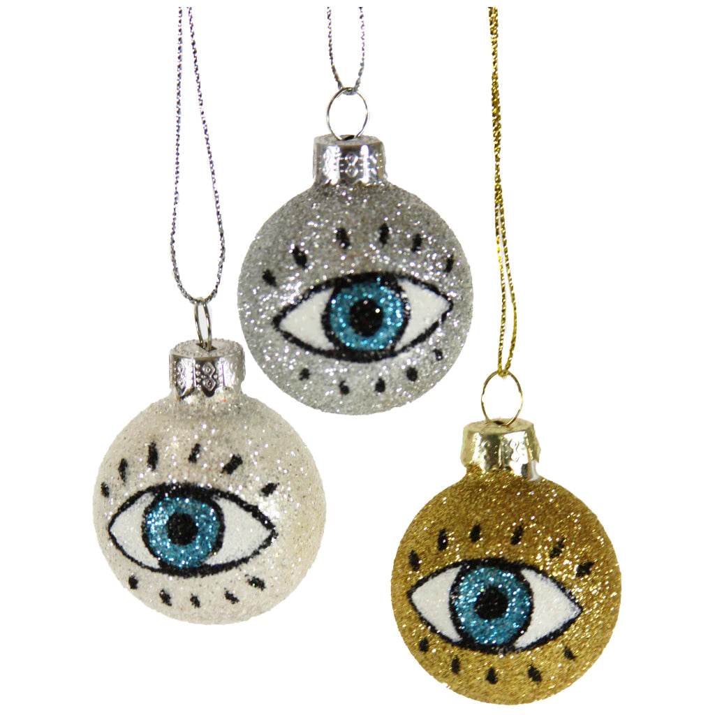 Trio of glittered round ornament featuring an eye. Color of ornaments are gold, silver and white.