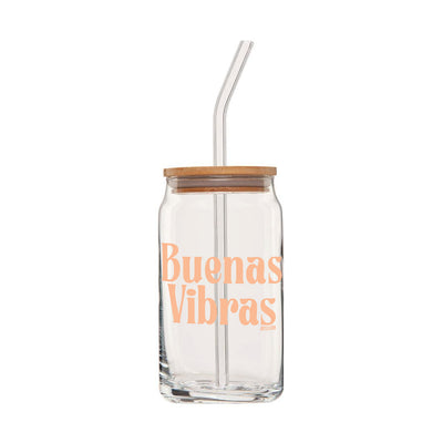 Clear can glass with the phrase Buenas Vibras in light orange lettering featuring a wooden lid and glass straw.