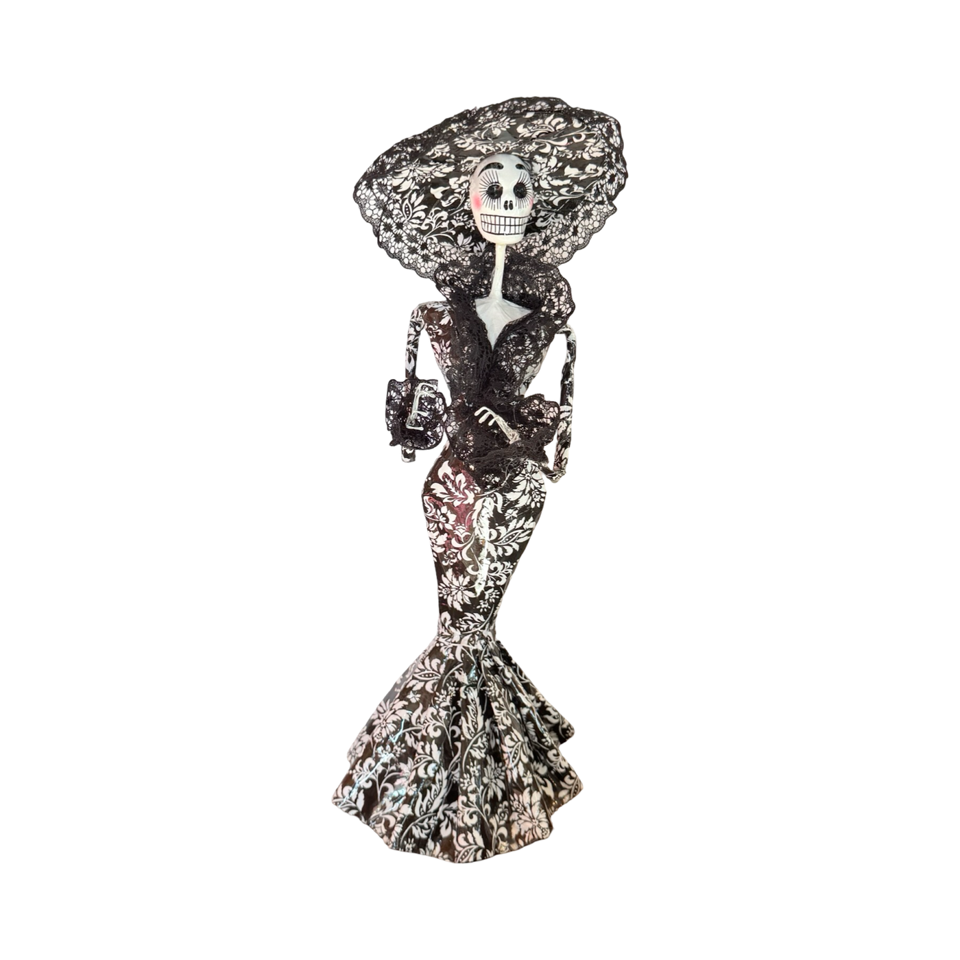 Día de Muertos Catrina figurine in a black and white floral gown with a matching wide-brimmed lace hat, holding a small handbag, handcrafted from papier-mâché.