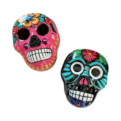 Set of colorful skull trinket boxes. One being pink with a colorful floral design and the other being Black with a colorful design.