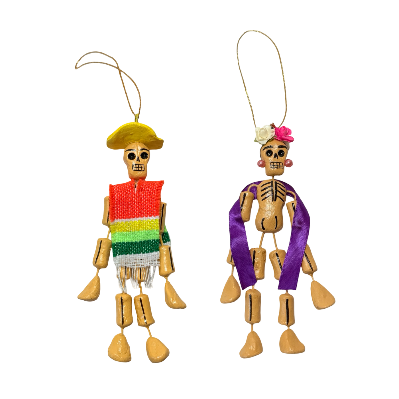 Two small Día de Muertos skeleton ornaments, one with a sombrero and poncho and the other with flowers, ribbon, and earrings.