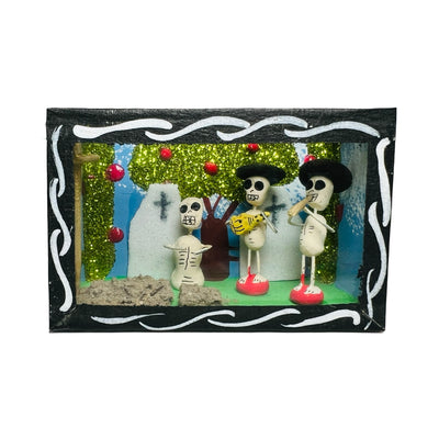 black nicho box that features a scene with skeletons in a cemetery