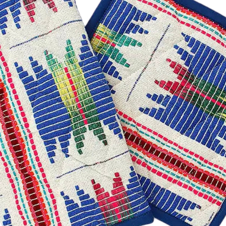 close up view of cream colored oven mitt and pot holder set with a blue, red and yellow/green tribal design.