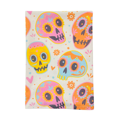 quarter folded cream kitchen towel with a pastel colored sugar skulls design