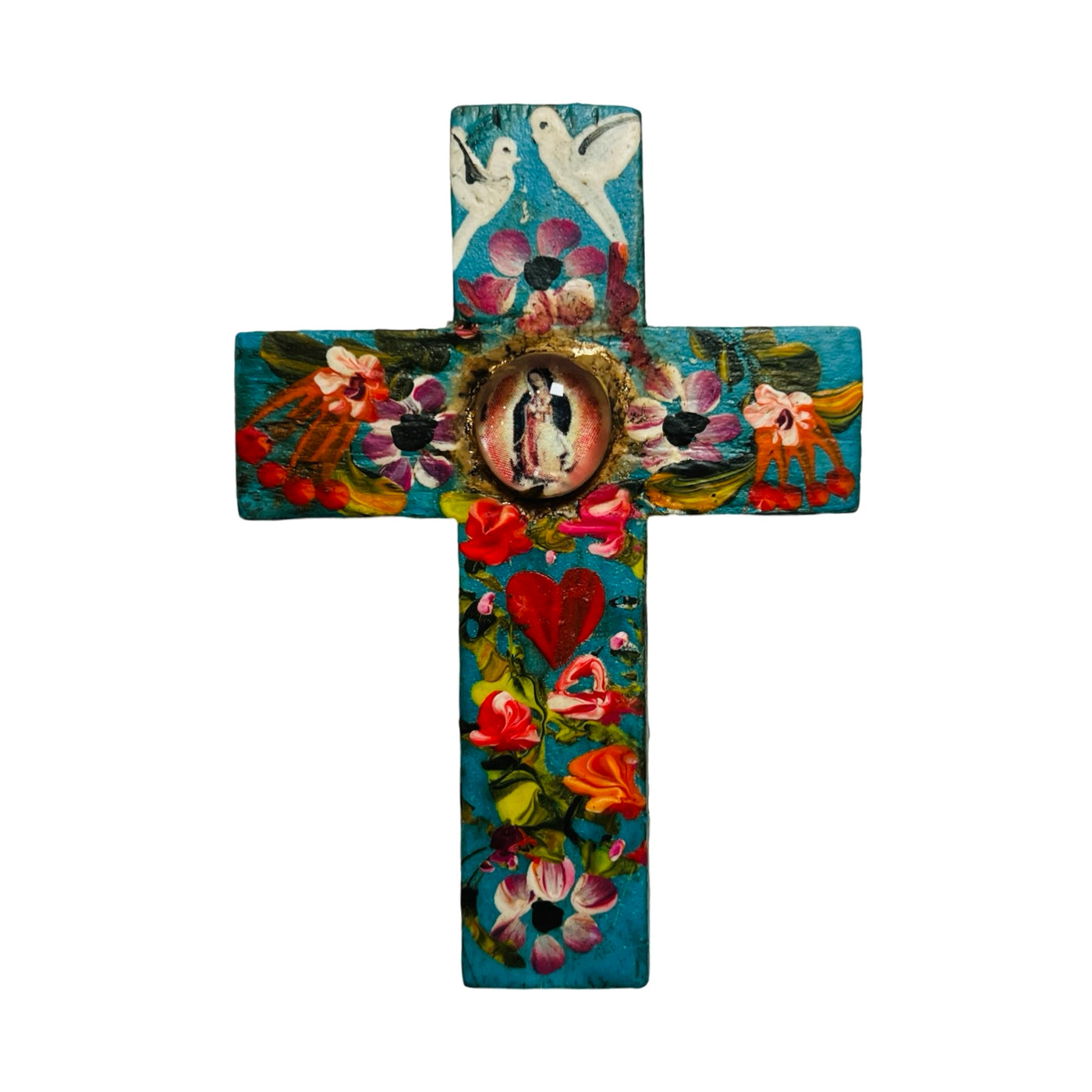 A hand-painted turquoise wooden cross featuring floral designs, white doves, and a central glass-encased image of the Virgen de Guadalupe. The cross is detailed with red heart motifs and colorful flowers in shades of pink, orange, and red, creating a vibrant and spiritual piece.