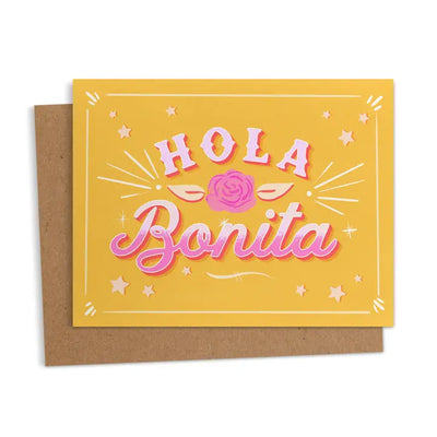 Greeting card with the words “Hola Bonita” in bold pink letters with a rose and star accents on a yellow background.