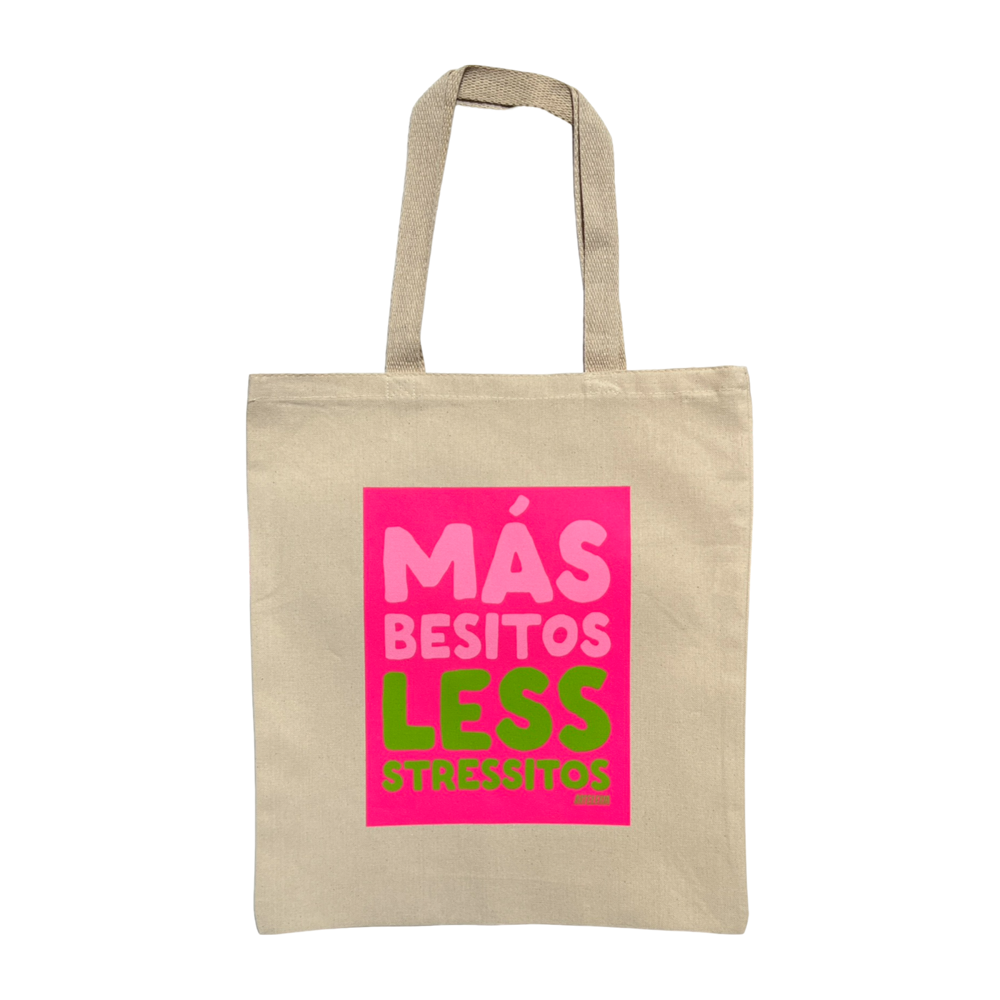 natural canvas tote back with a hot pink rectangle block and the phrase Mas Besitos Less Stressitos in light pink and green lettering
