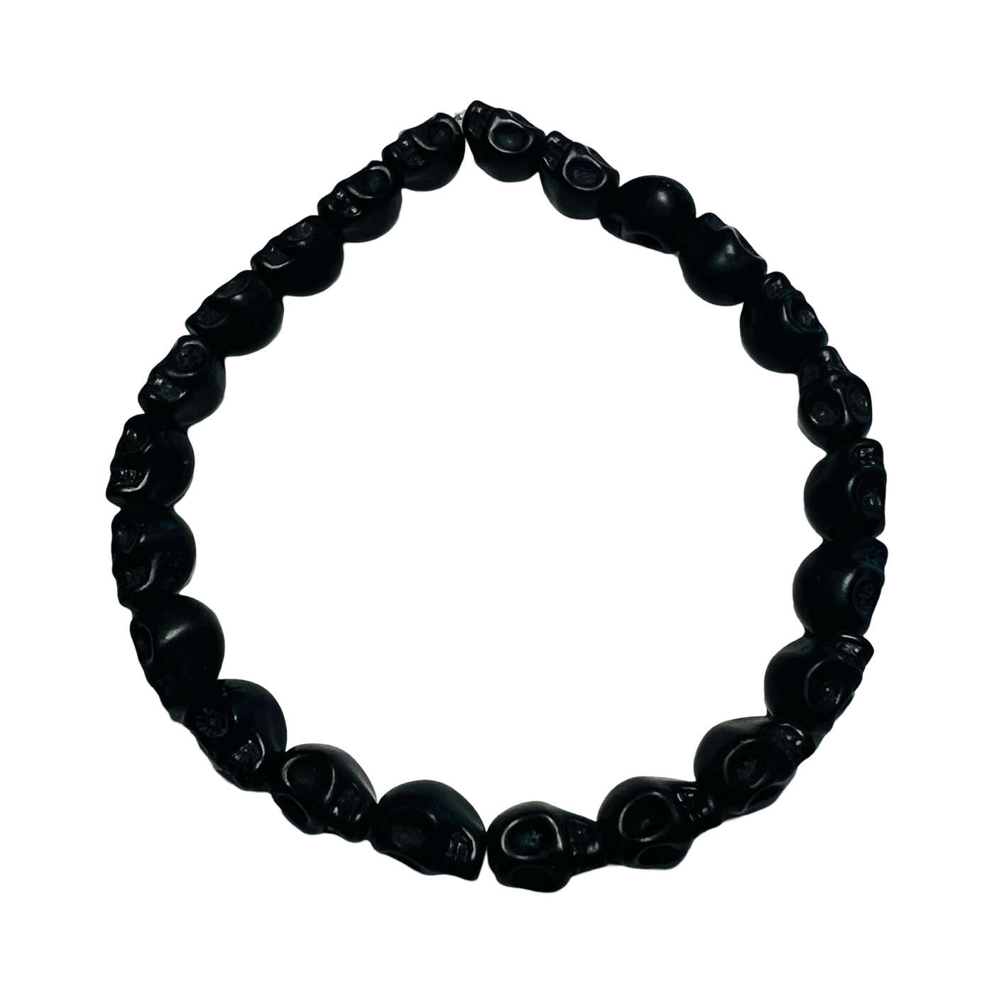 A Mexican Skull Bead Bracelet made of black, hand-carved skull-shaped beads, strung on an elastic band.