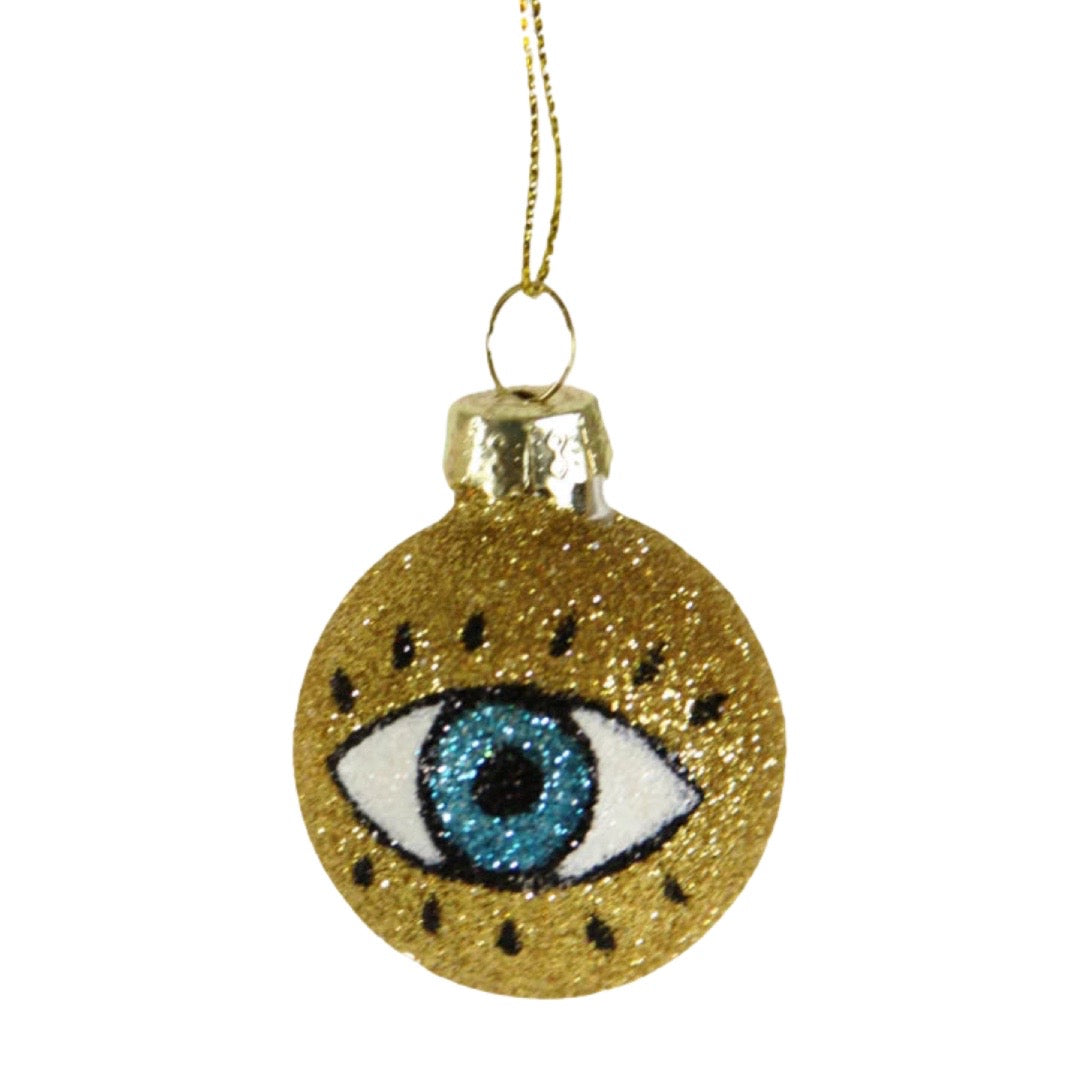 gold glittered round ornament featuring an image of an eye