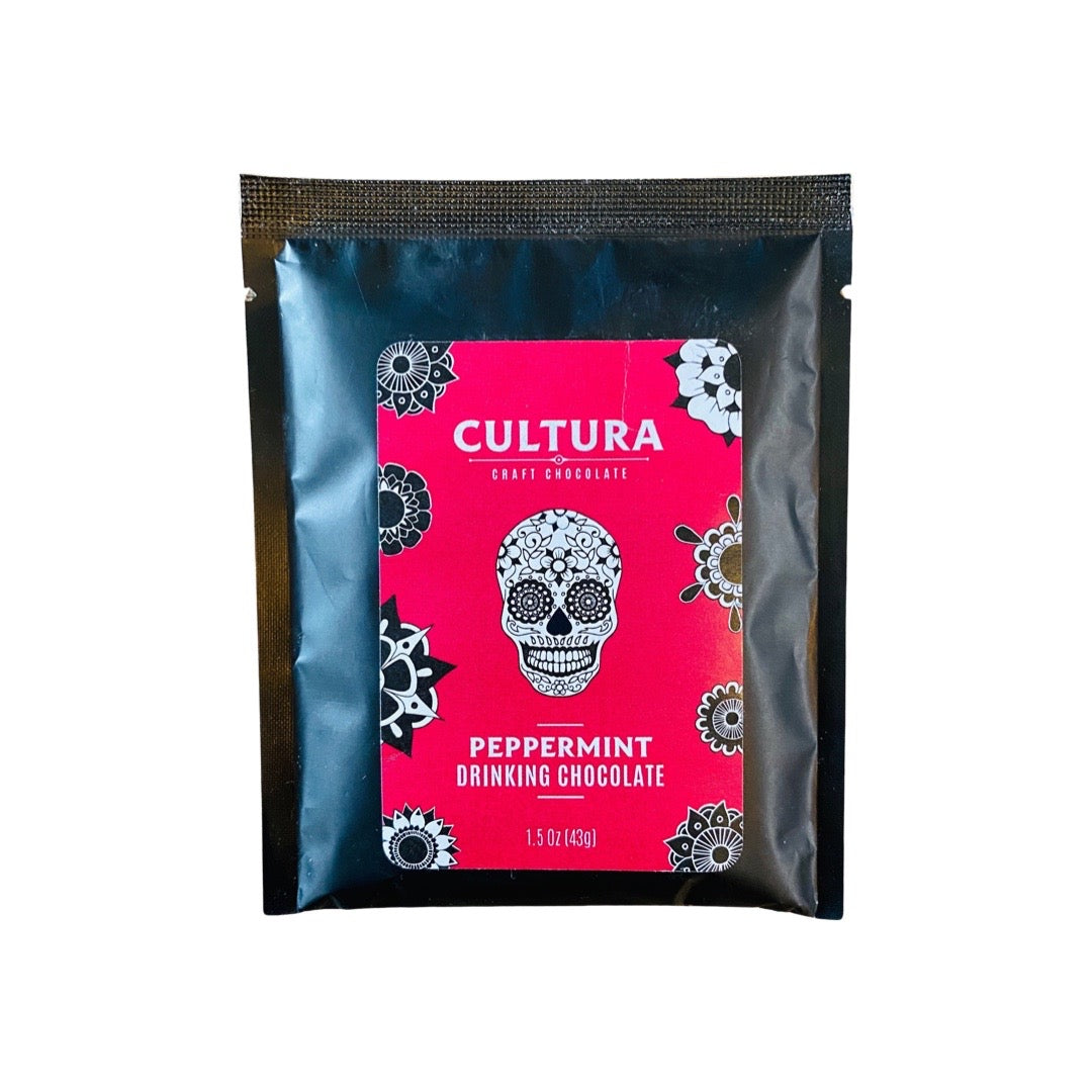 1.5 oz black packet of peppermint hot chocolate with a red label that features a sugar skull.