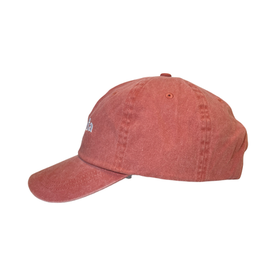 Side view of a coral hat with the phrase La Jefa in white lettering