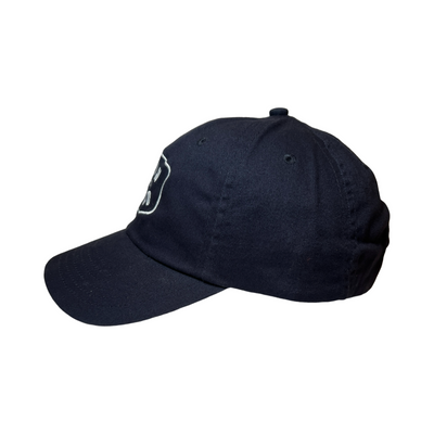 Side View of a navy blue hat with the Phrase Juan of a Kind in white letteing