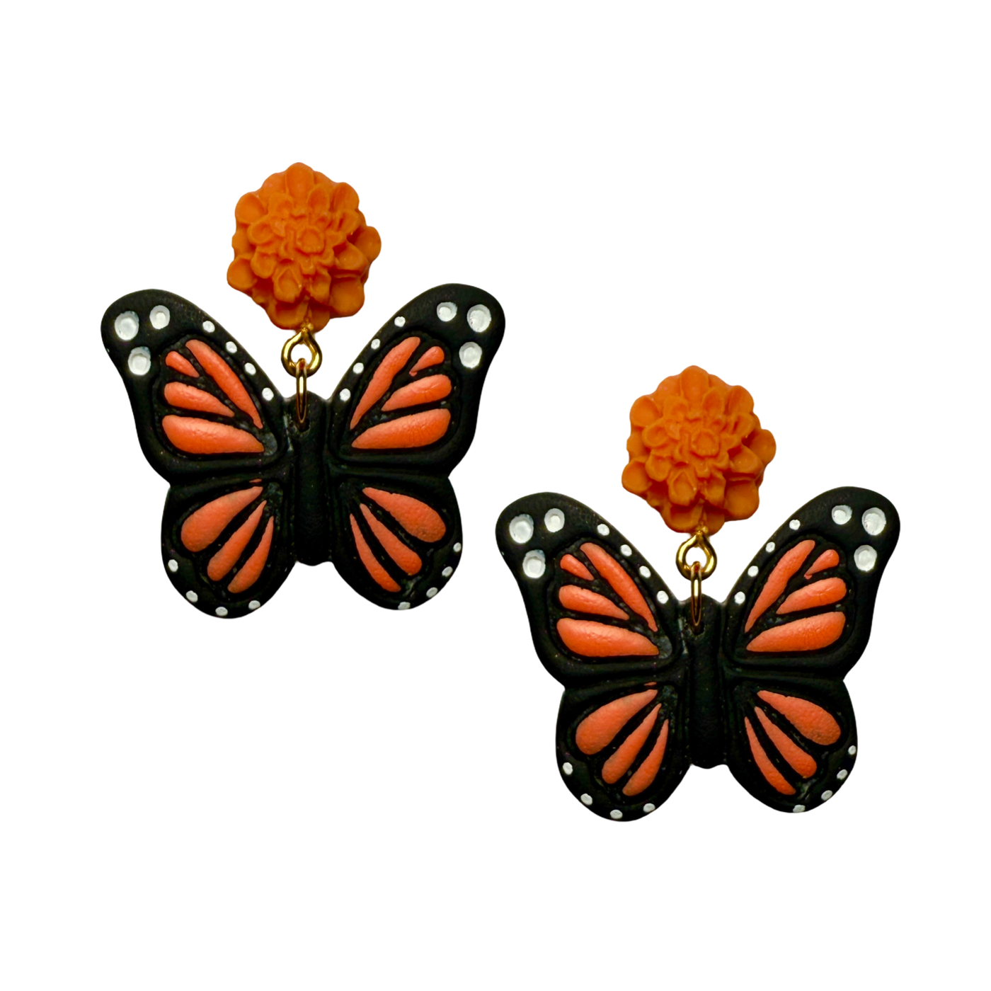 Handmade earrings with bright orange marigold flower studs and dangling monarch butterfly designs in black, orange, and white.