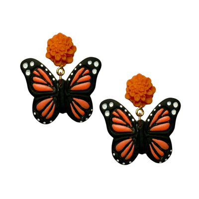 Handmade earrings with bright orange marigold flower studs and dangling monarch butterfly designs in black, orange, and white.