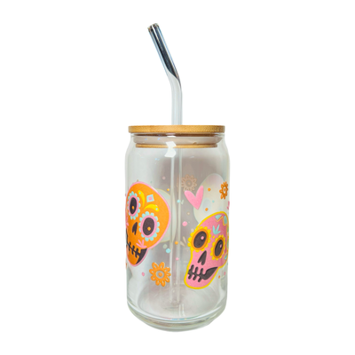 clear glass can tumbler with a glass straw featuring two colorful sugar skulls, hearts and flowers.