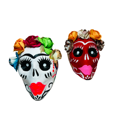 set of colorful paper mache frida sugar skull in multiple colors featuring a flower crown on each.