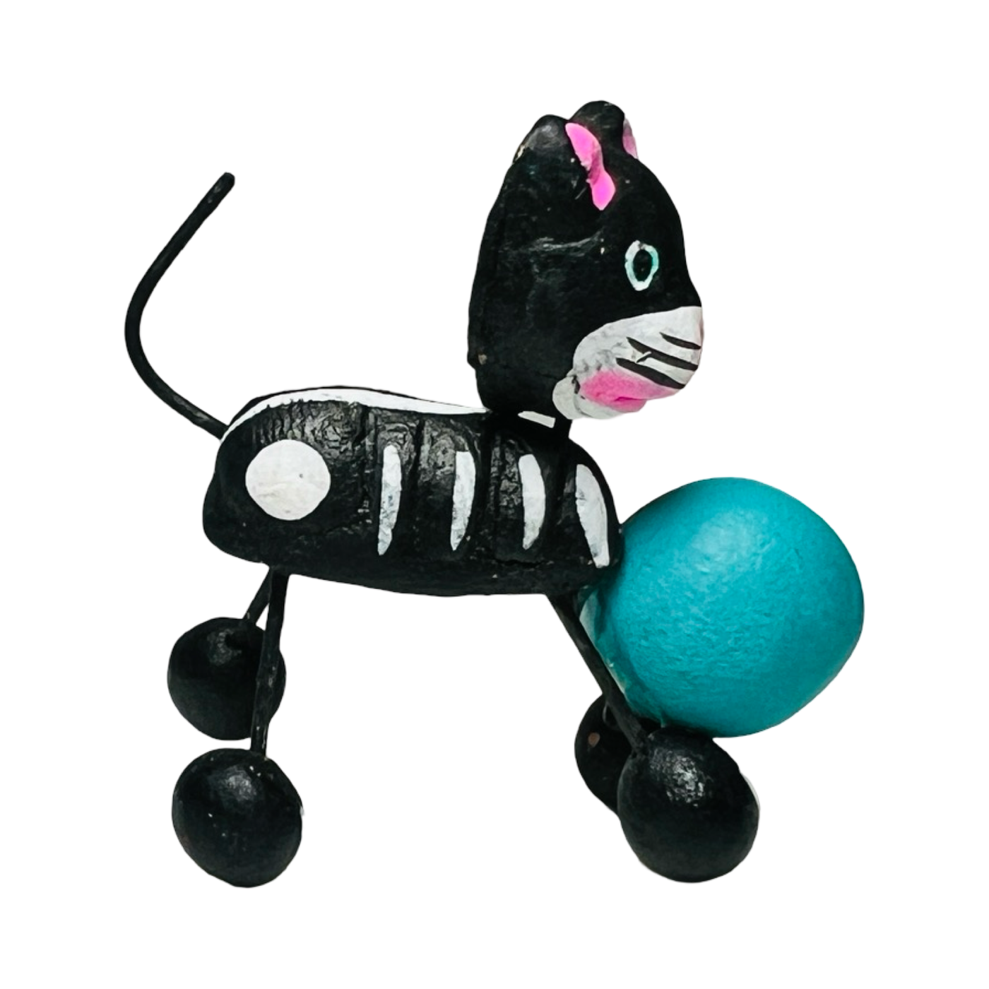 black cat calavera figurine playing with a teal ball