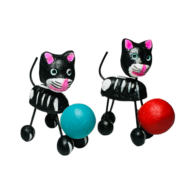 set of two black cat calavera figurines with each holding a colorful ball.