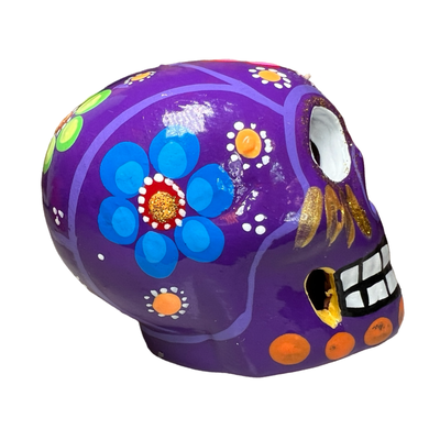 side view of a purple ceramic sugar skull with a floral design.